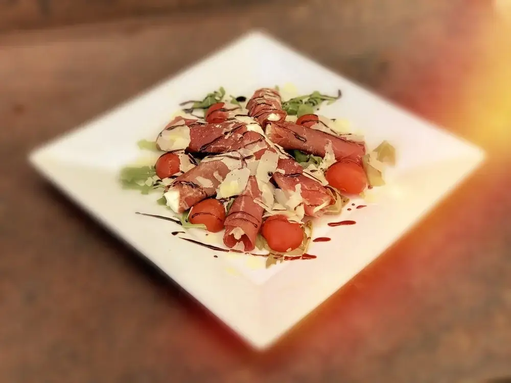 Bresaola stuffed with Ontario brie on a bed of arugula and parmesan cheese