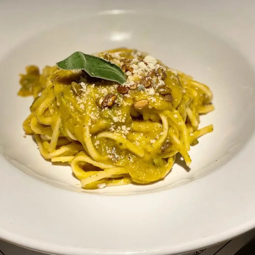 Linguine pasta with oven roasted puréed squash topped with candied pumpkin seeds, parmesan cheese and a hint of spice.