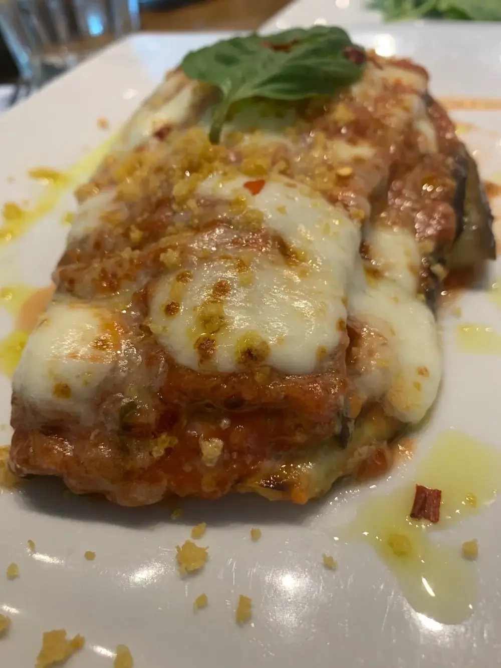 Eggplant parmigiana  Oven roasted eggplant, mozzarella cheese and tomato sauce with a touch of spice baked in our oven. *Gluten Free